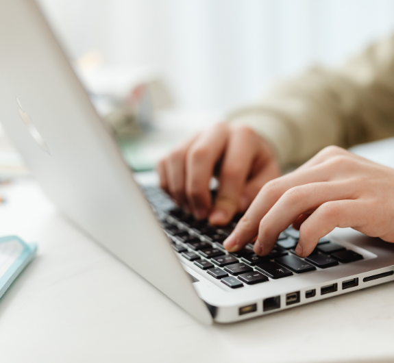 Hands typing on laptop